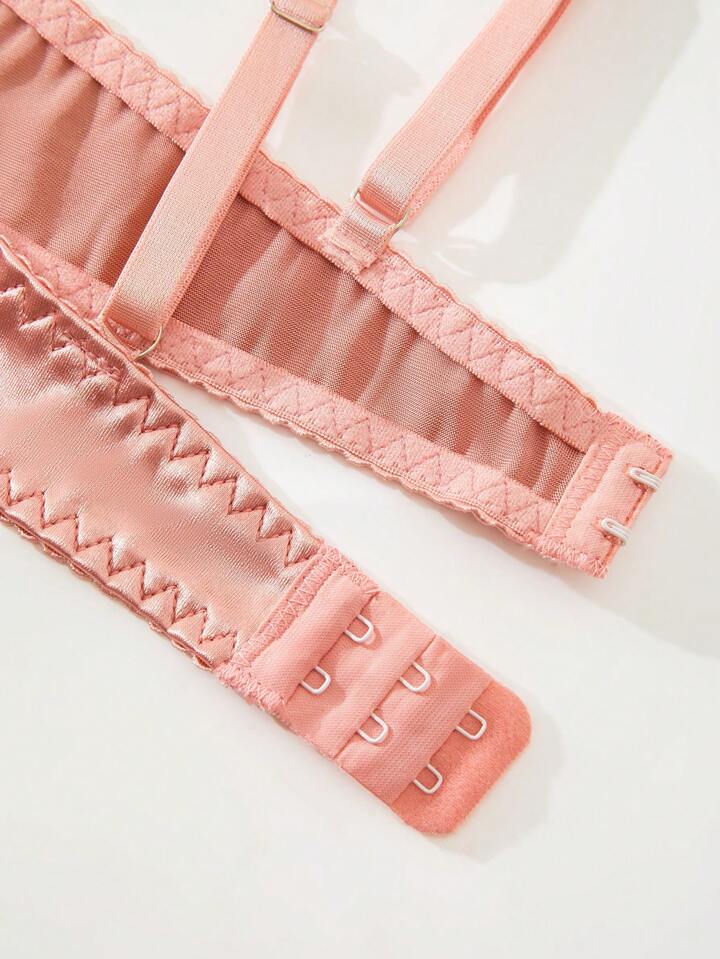 Close-up of pink lingerie with lace details on a white background