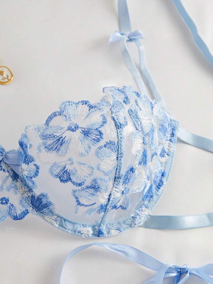 Blue floral lace bralette with matching panties on a light background