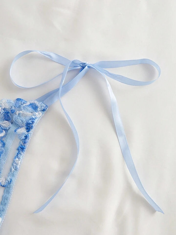 Blue lace lingerie with a ribbon on a light background