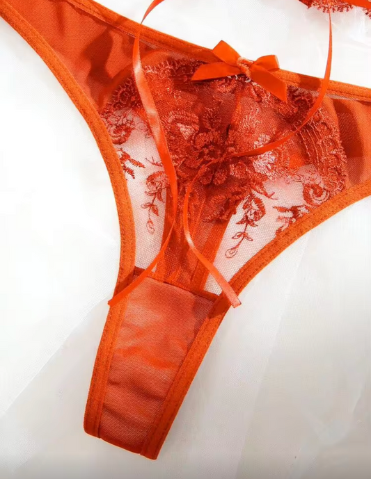 An orange sheer lace thong with a matching bow, displayed on a white background perfect for halloween or fall autumn lingerie