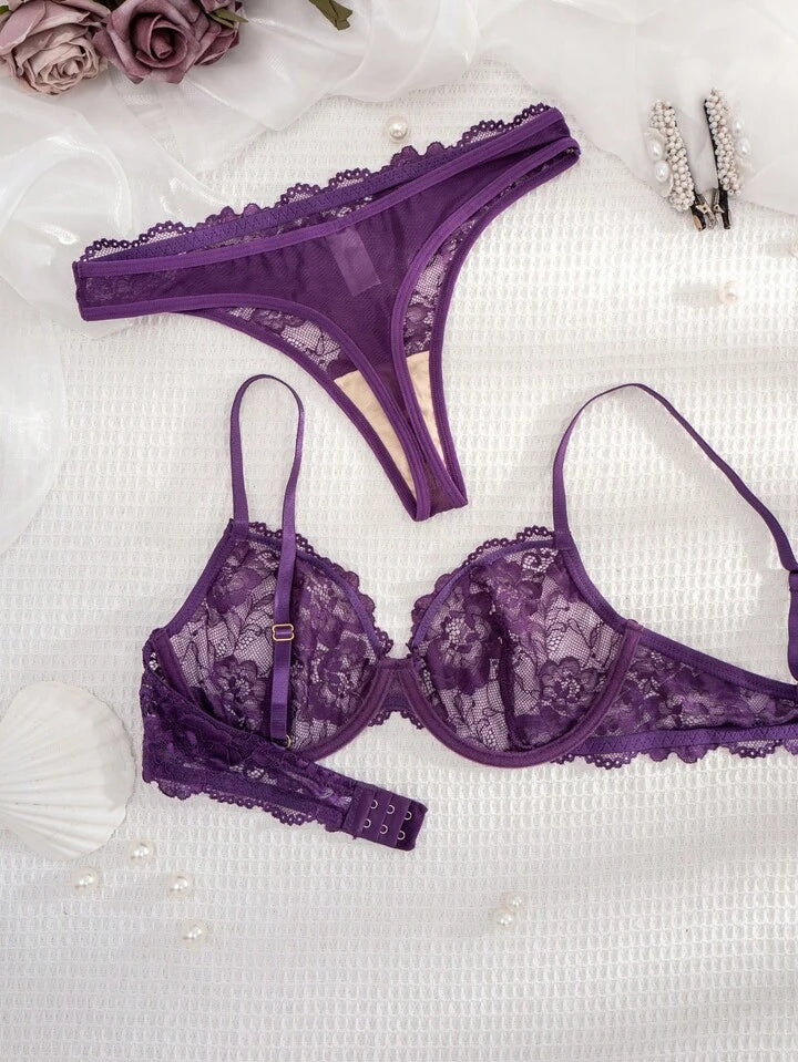 Purple lace lingerie set on a white background with flowers and jewelry.