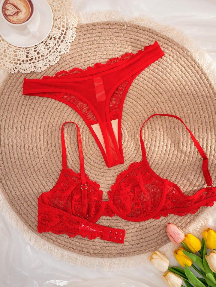 Red lace lingerie set on a woven mat with a cup of coffee and tulips.