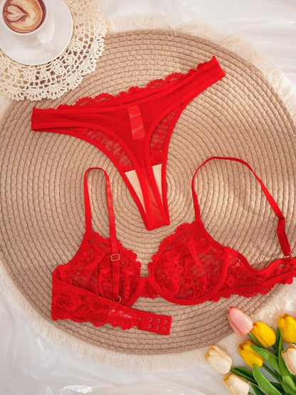 Red lace lingerie set on a woven mat with a cup of coffee and tulips.