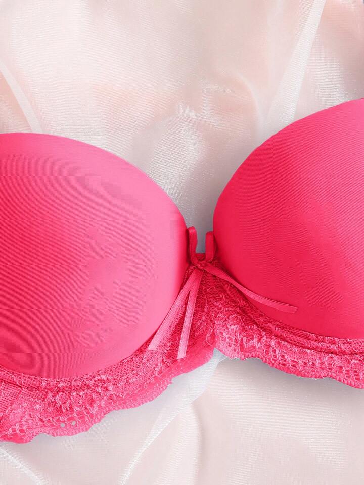 Close-up of a pink bra with lace trim on a white background