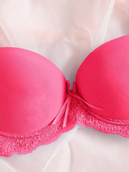 Close-up of a pink bra with lace trim on a white background