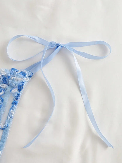 Blue lace lingerie with a ribbon on a light background