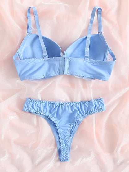 Light blue bra and panties set on a pink background