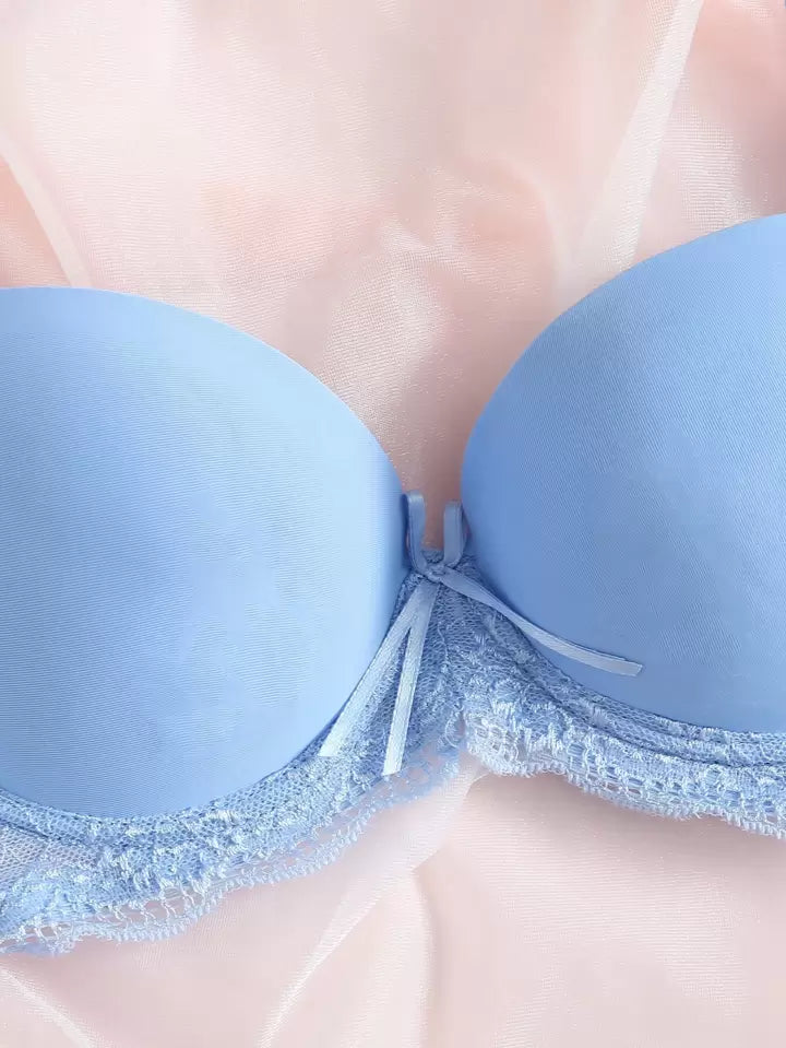 Light blue bra with lace trim on a neutral background