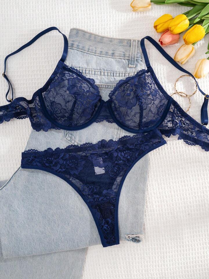 Navy blue lace lingerie set with denim shorts on a white surface with tulips.