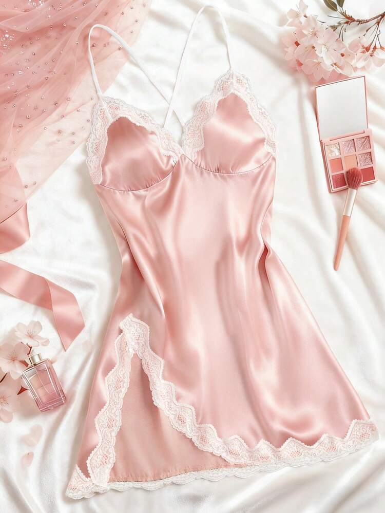 Pink satin nightgown with lace details on a white surface, surrounded by beauty products.