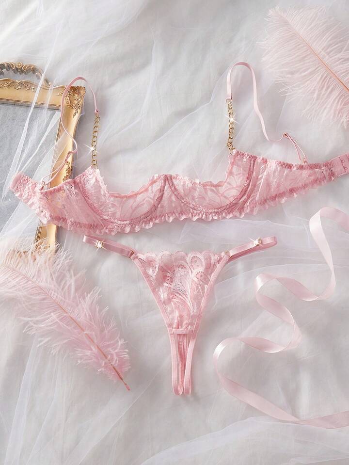 Pink lace lingerie set on a white fabric background