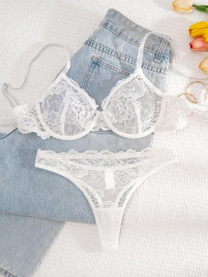 White lace lingerie set with denim shorts on a light background