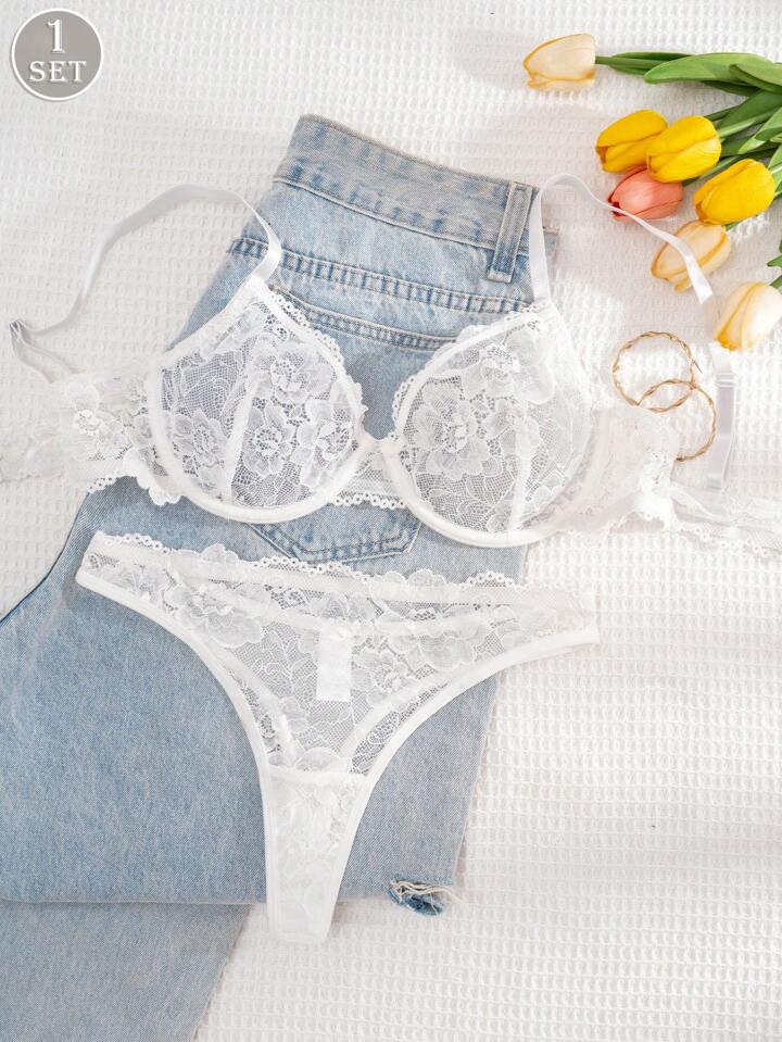 White lace lingerie set with denim shorts on a white background with tulips.
